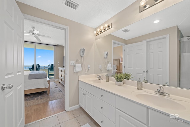 375 Beach Club Trl Unit B404, Gulf Shores, AL 36542 - full bathroom with connected bathroom, double vanity, a textured ceiling, tile patterned floors, and a ceiling fan