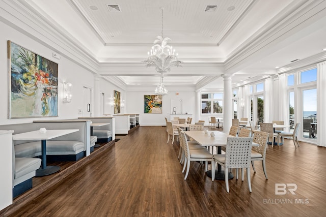 375 Beach Club Trl Unit B404, Gulf Shores, AL 36542 - dining space with a tray ceiling, a chandelier, dark wood finished floors, crown molding, and decorative columns