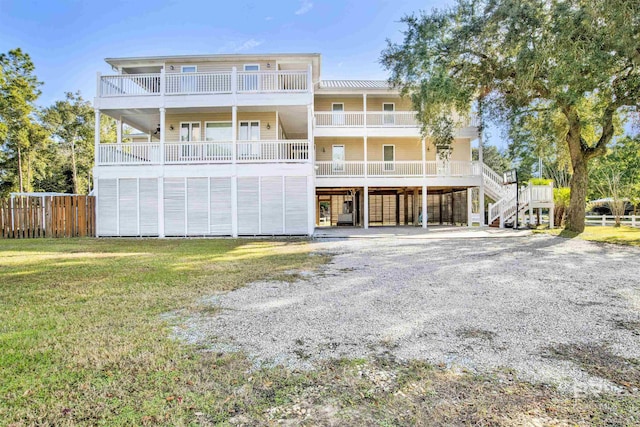 rear view of house featuring a lawn and a carport