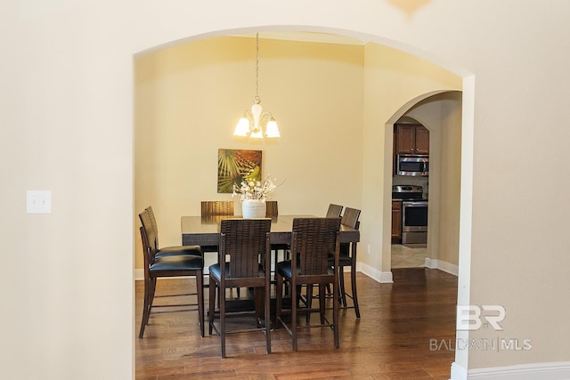 dining space with dark hardwood / wood-style flooring and a notable chandelier