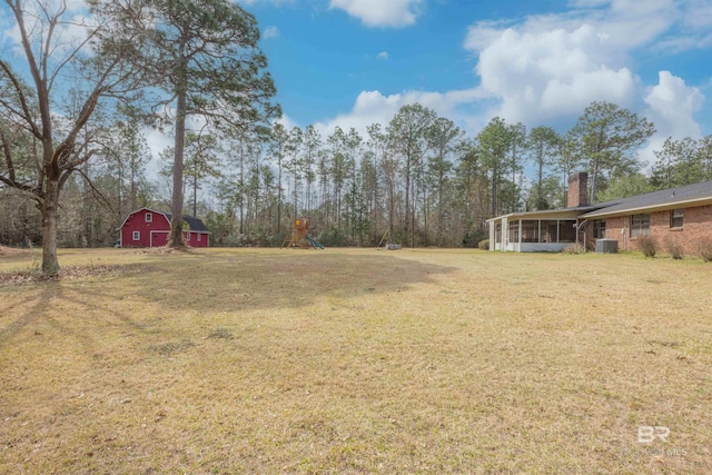 view of yard featuring an outbuilding, a barn, central AC unit, and a sunroom