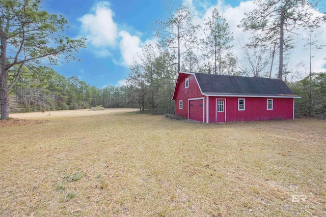 view of yard featuring a barn, an outbuilding, and a garage