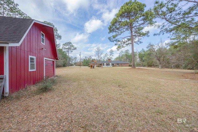 view of yard featuring a garage and an outdoor structure