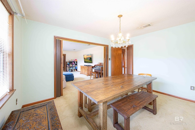 dining room featuring baseboards, visible vents, light carpet, and an inviting chandelier