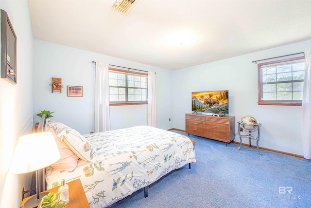 carpeted bedroom featuring visible vents and baseboards