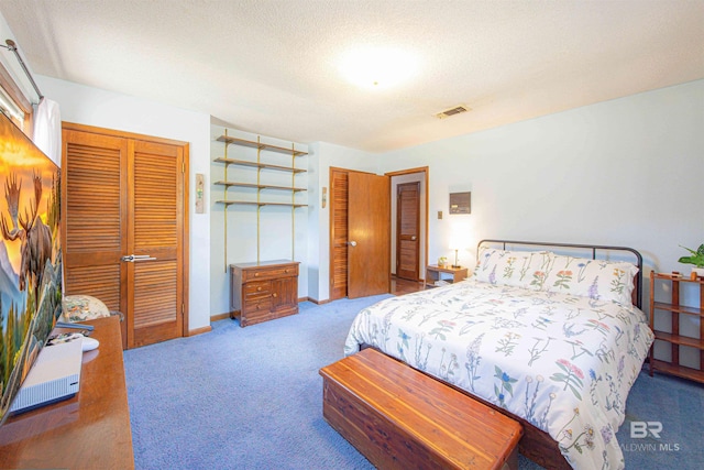 carpeted bedroom with a closet, visible vents, a textured ceiling, and baseboards