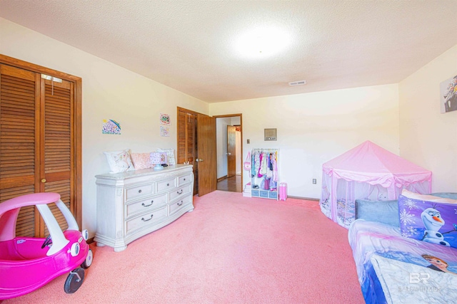 recreation room with visible vents, carpet floors, and a textured ceiling