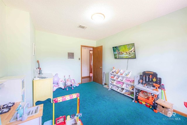 recreation room featuring visible vents, a textured ceiling, and carpet floors