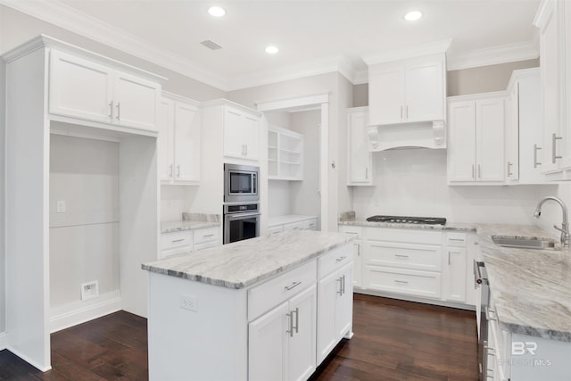 kitchen with sink, stainless steel appliances, a center island, custom range hood, and white cabinets