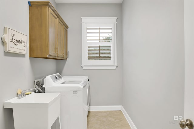 laundry room with cabinets, independent washer and dryer, and sink