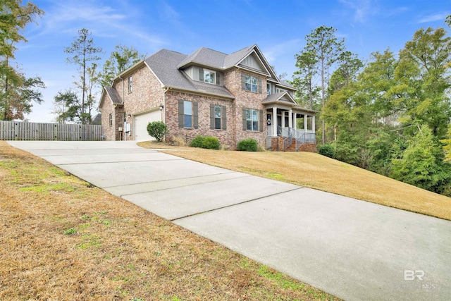 view of front of house with a porch, a garage, and a front yard