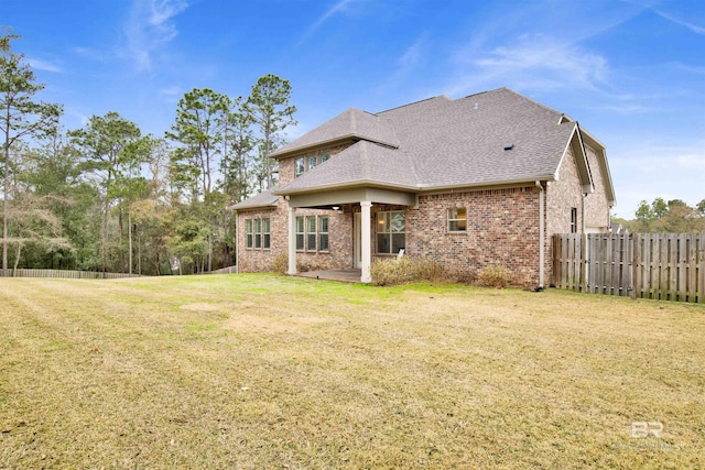 back of property with a yard and a patio area