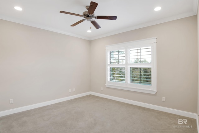 carpeted spare room featuring crown molding and ceiling fan