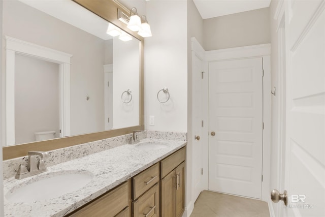 bathroom featuring vanity, tile patterned flooring, and toilet