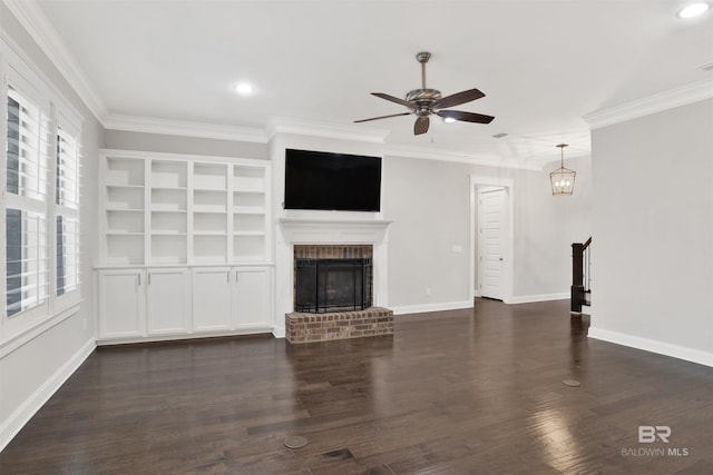 unfurnished living room featuring a brick fireplace, ornamental molding, dark hardwood / wood-style floors, and ceiling fan