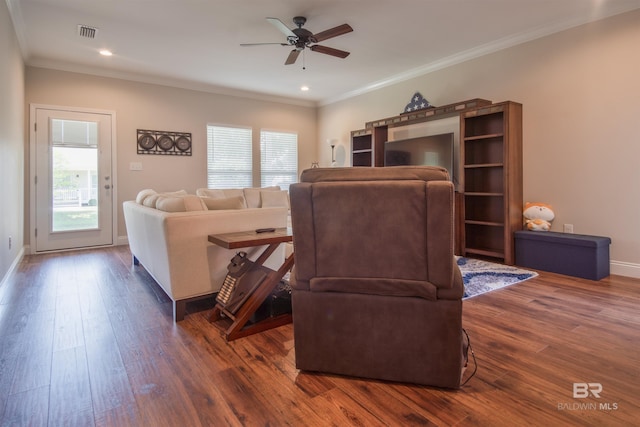 living room with ornamental molding, ceiling fan, and dark wood-type flooring