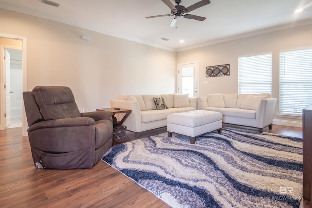 living room with plenty of natural light, crown molding, ceiling fan, and wood-type flooring