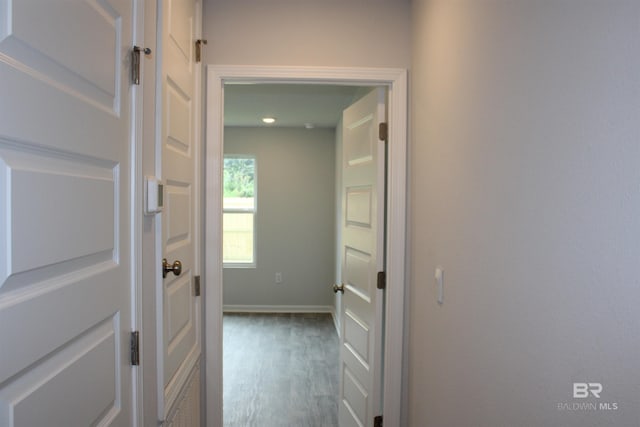 hall with wood finished floors and baseboards