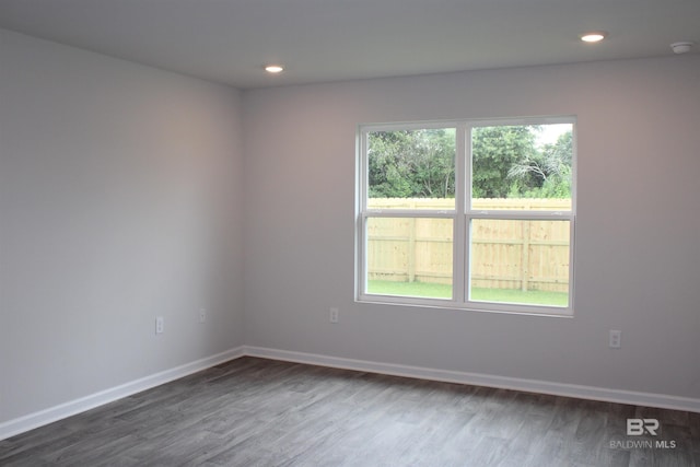 unfurnished room featuring recessed lighting, dark wood finished floors, and baseboards