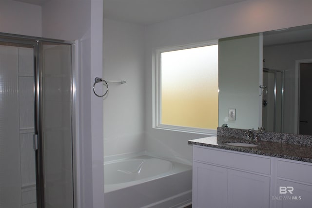 bathroom with a stall shower, a garden tub, and vanity