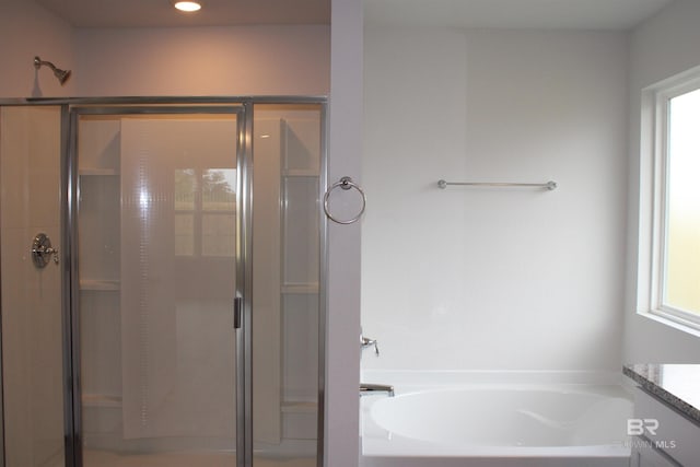 bathroom with recessed lighting, a garden tub, a shower stall, and vanity