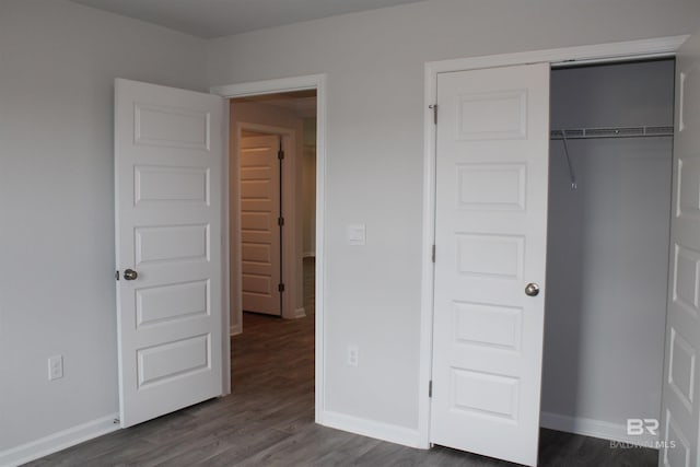 unfurnished bedroom featuring dark wood-type flooring and baseboards