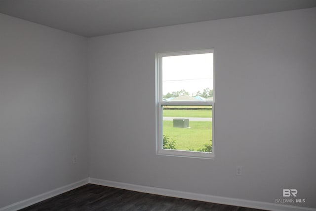 unfurnished room with dark wood-style flooring and baseboards