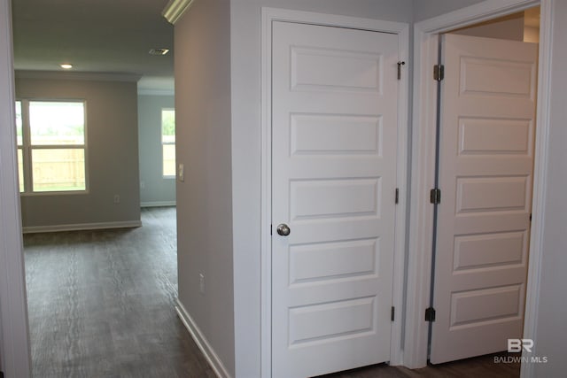 hall featuring ornamental molding, visible vents, baseboards, and dark wood-style floors