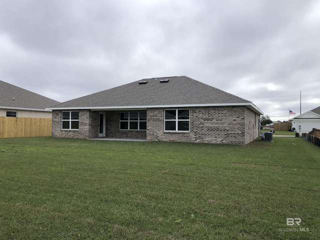 back of house featuring a yard, fence, cooling unit, and brick siding