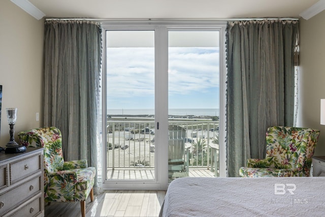 bedroom with ornamental molding, multiple windows, access to exterior, and light wood-type flooring