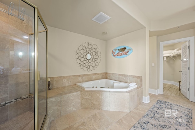 bathroom with tile flooring and separate shower and tub