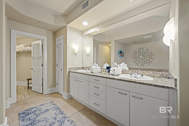 bathroom with dual bowl vanity and tile flooring