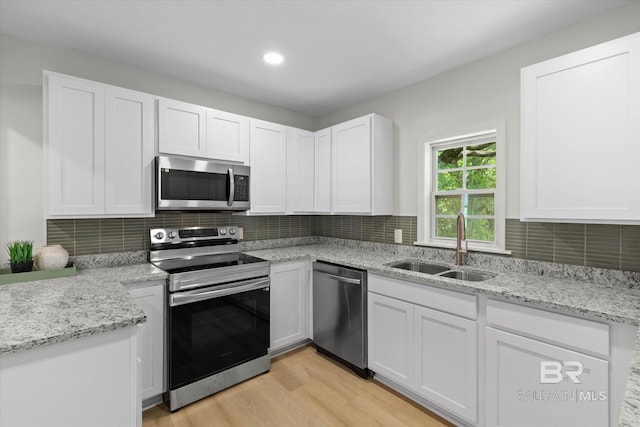 3512 Spring Hill Ave, Mobile, AL 36608 - kitchen with appliances with stainless steel finishes, white cabinetry, tasteful backsplash, light wood-style flooring, and recessed lighting