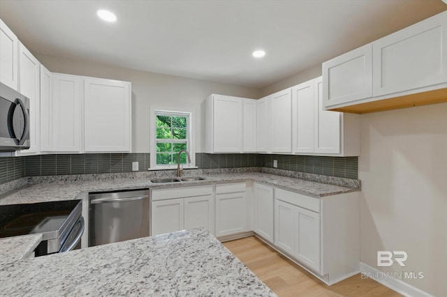 3512 Spring Hill Ave, Mobile, AL 36608 - kitchen featuring appliances with stainless steel finishes, tasteful backsplash, light wood-type flooring, white cabinets, and recessed lighting