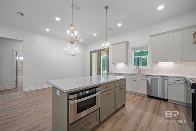 12380 Mannich Ln, Foley, AL 36580 - kitchen featuring stainless steel appliances, a chandelier, decorative backsplash, light wood-style flooring, and recessed lighting