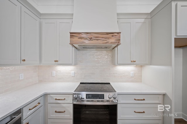 12380 Mannich Ln, Foley, AL 36580 - kitchen with stainless steel electric range oven, custom range hood, light countertops, tasteful backsplash, and white cabinets