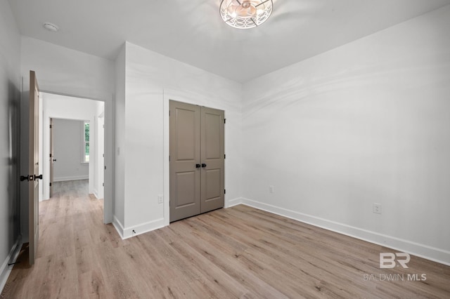 12380 Mannich Ln, Foley, AL 36580 - unfurnished bedroom featuring light wood finished floors, baseboards, and a closet