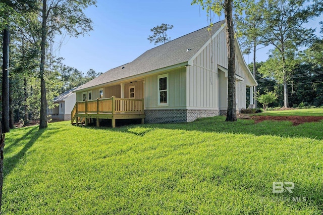 12380 Mannich Ln, Foley, AL 36580 - rear view of house with board and batten siding, a wooden deck, a yard, and a shingled roof