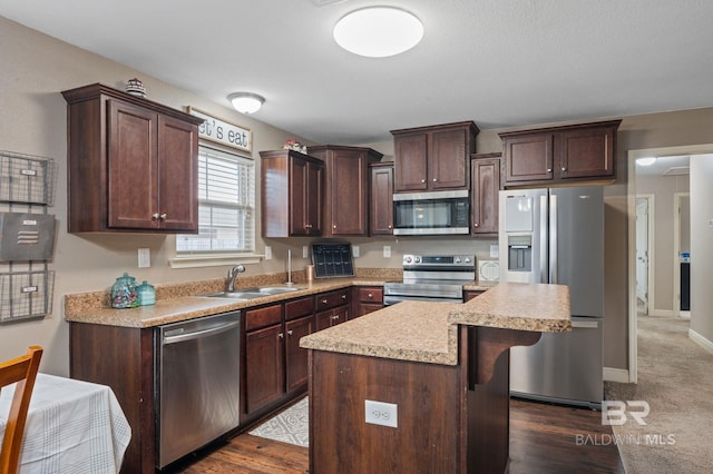 kitchen with appliances with stainless steel finishes, a kitchen island, dark hardwood / wood-style floors, sink, and dark brown cabinets