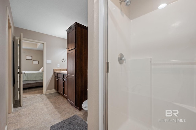 bathroom featuring toilet, walk in shower, and vanity