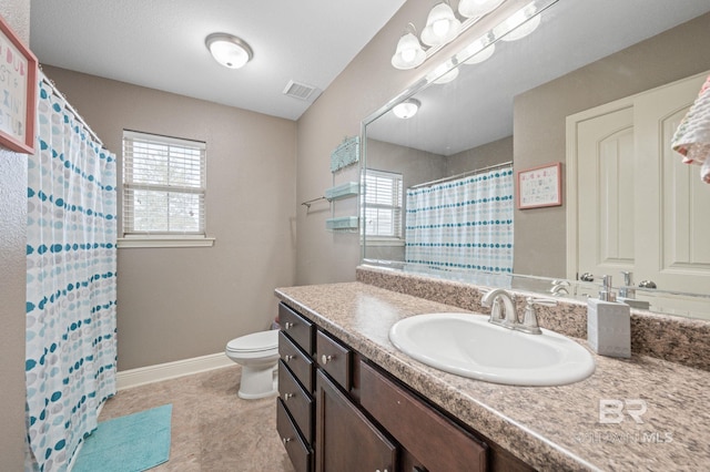 bathroom with toilet, a shower with shower curtain, vanity, and plenty of natural light