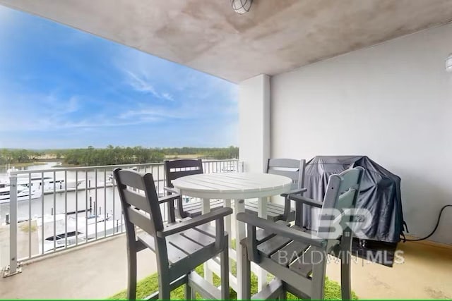 balcony featuring a water view and outdoor dining space