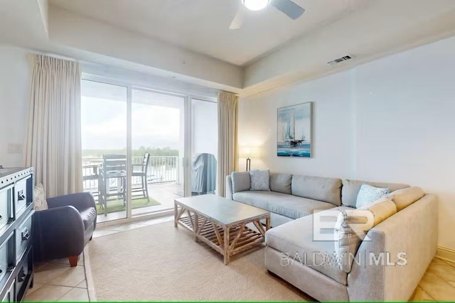 living room featuring light tile patterned floors, visible vents, and a ceiling fan