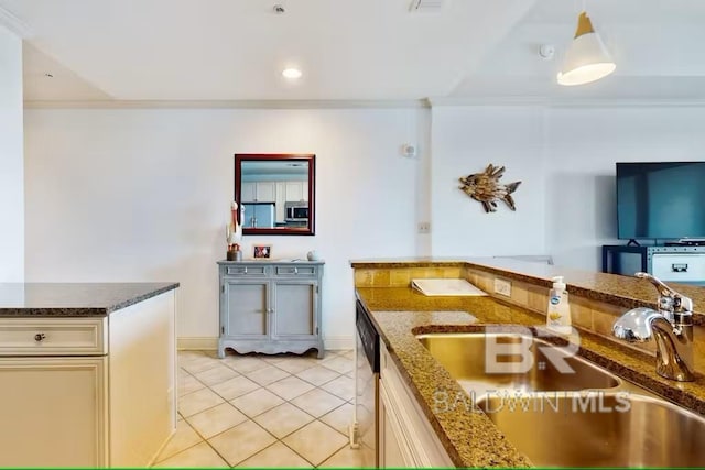kitchen with crown molding, appliances with stainless steel finishes, light tile patterned flooring, a sink, and dark stone countertops