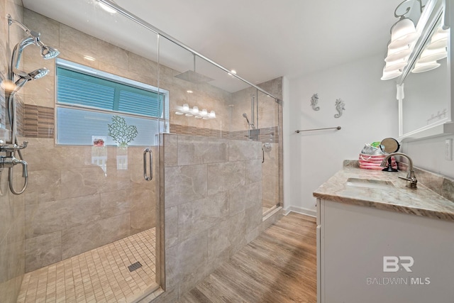 bathroom featuring hardwood / wood-style flooring, vanity, and an enclosed shower