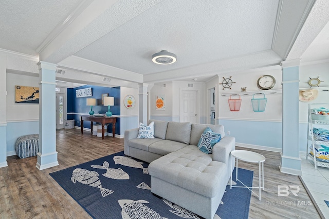 living room with decorative columns, crown molding, hardwood / wood-style floors, and a textured ceiling