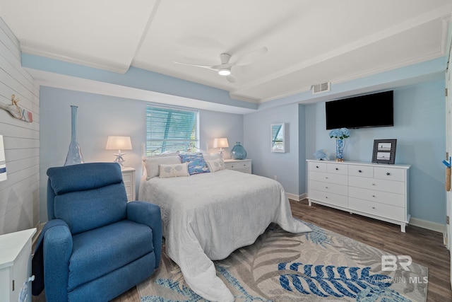 bedroom with wood-type flooring, wooden walls, and ceiling fan