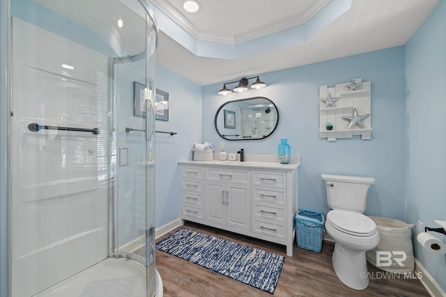 bathroom featuring crown molding, hardwood / wood-style floors, vanity, a shower with shower door, and a raised ceiling