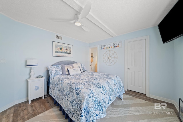 bedroom featuring hardwood / wood-style floors, a textured ceiling, and ceiling fan