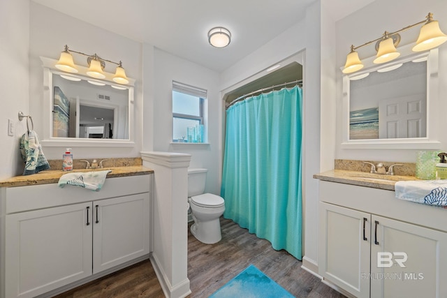 bathroom with wood-type flooring, toilet, and vanity